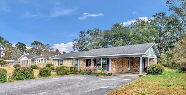 ranch-style home with a front yard and a carport