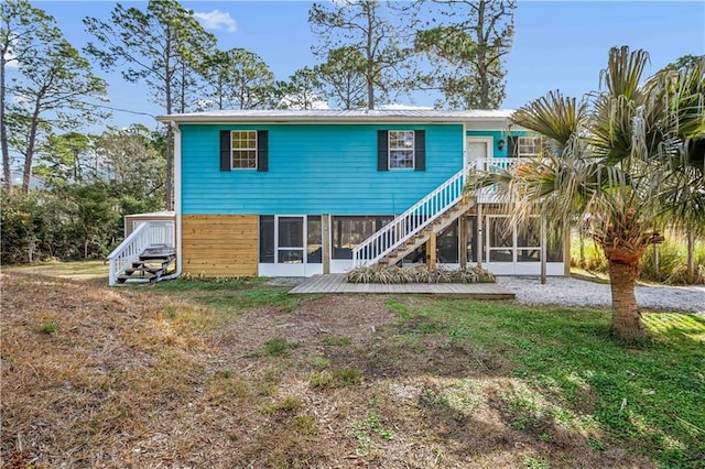 back of property featuring a wooden deck and a sunroom