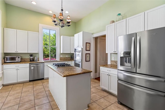 kitchen with white cabinetry, a chandelier, a center island, appliances with stainless steel finishes, and light tile patterned flooring