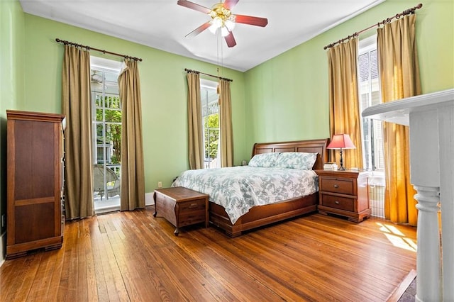bedroom featuring access to outside, hardwood / wood-style floors, and ceiling fan