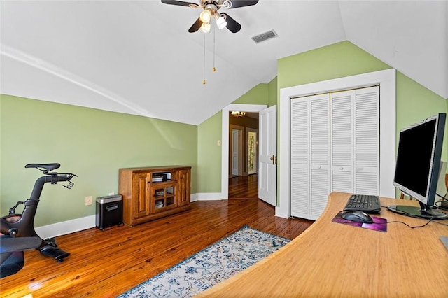 office space featuring ceiling fan, vaulted ceiling, visible vents, wood-type flooring, and baseboards