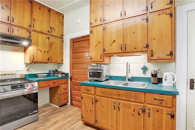 kitchen featuring stainless steel range oven, sink, and light hardwood / wood-style floors