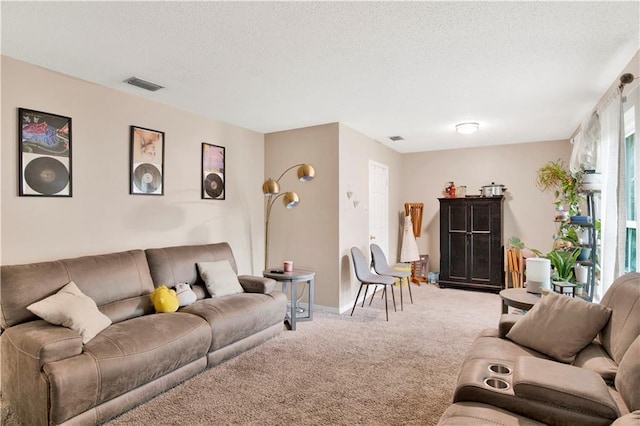 living room with carpet, a textured ceiling, and visible vents