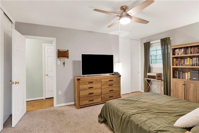 carpeted bedroom with baseboards and a ceiling fan