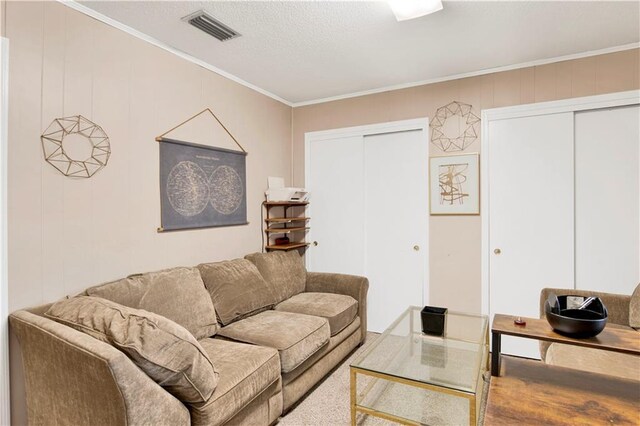living area with ornamental molding and visible vents