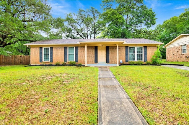 ranch-style house featuring fence, brick siding, and a front yard