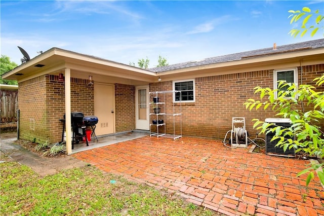 back of property featuring brick siding and a patio