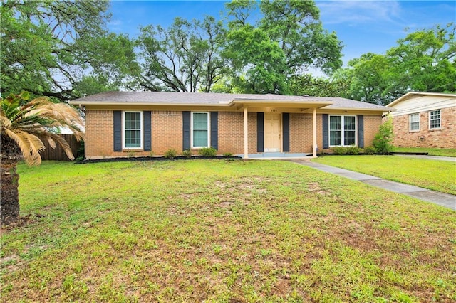 ranch-style home with fence, brick siding, and a front yard