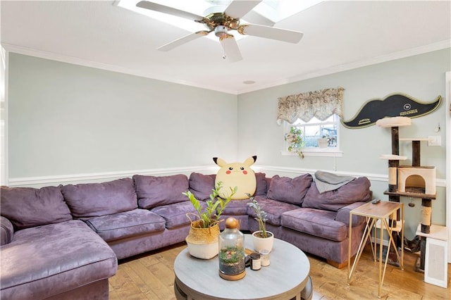 living room with ornamental molding, a ceiling fan, and light wood finished floors