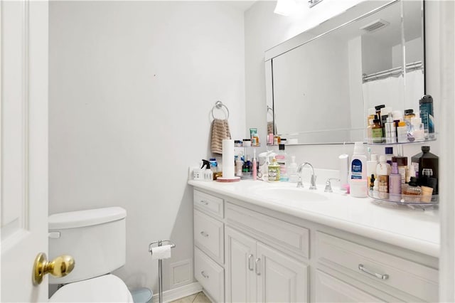 bathroom with vanity, toilet, and visible vents