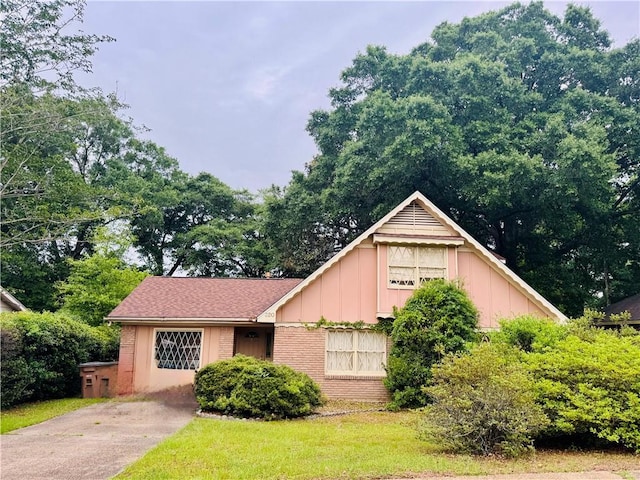 view of front of property with brick siding, board and batten siding, and concrete driveway