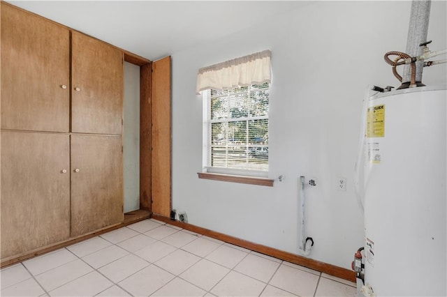 interior space featuring water heater, light tile patterned floors, and a closet