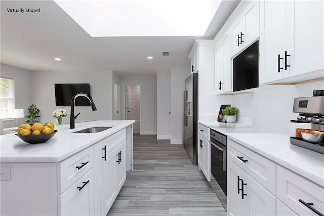 5023 Santos Dr W, Mobile, AL 36619 - kitchen featuring stainless steel refrigerator with ice dispenser, light wood-style flooring, recessed lighting, white cabinets, and light countertops