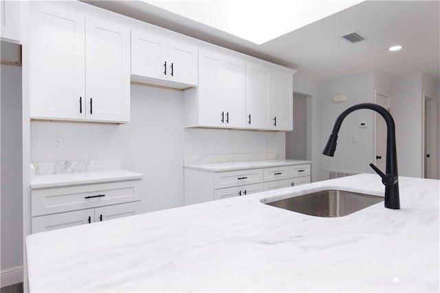 5023 Santos Dr W, Mobile, AL 36619 - kitchen with light stone counters, white cabinets, and recessed lighting