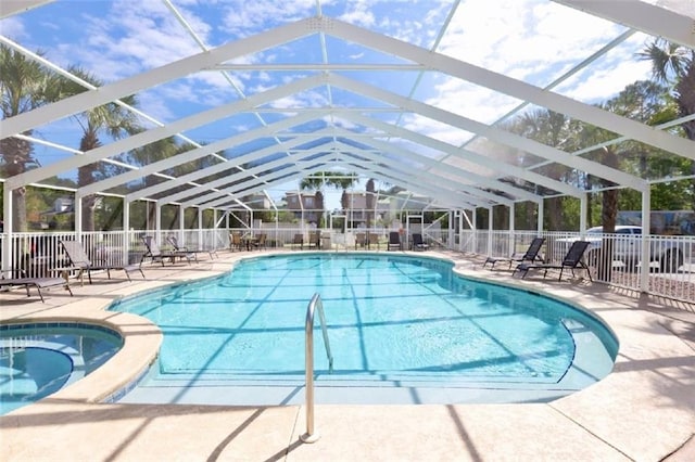 view of swimming pool with glass enclosure and a patio area