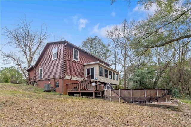 back of house featuring central AC unit, a sunroom, a yard, and a deck