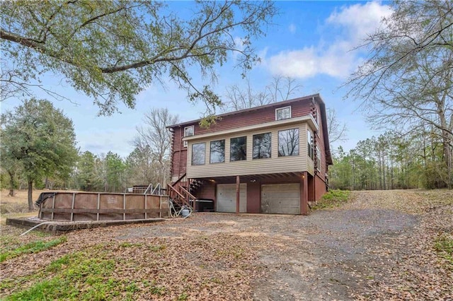 view of side of property with a pool and a garage