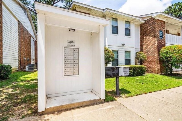 6050 Grelot Rd Unit 202, Mobile, AL 36609 - view of exterior entry featuring a lawn and cooling unit