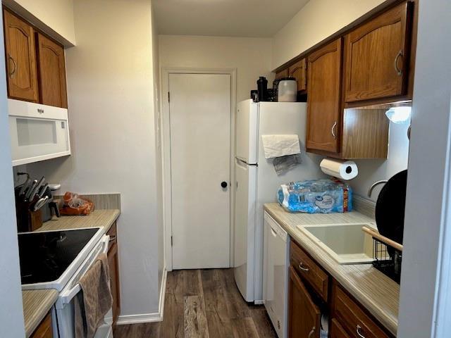 6050 Grelot Rd Unit 202, Mobile, AL 36609 - kitchen with dark wood-type flooring, light countertops, brown cabinetry, and white appliances