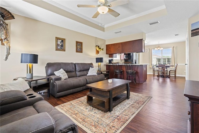 13578 James Copeland Dr, Mobile, AL 36695 - living room with a raised ceiling, ceiling fan, dark wood-style flooring, ornamental molding, and a chandelier