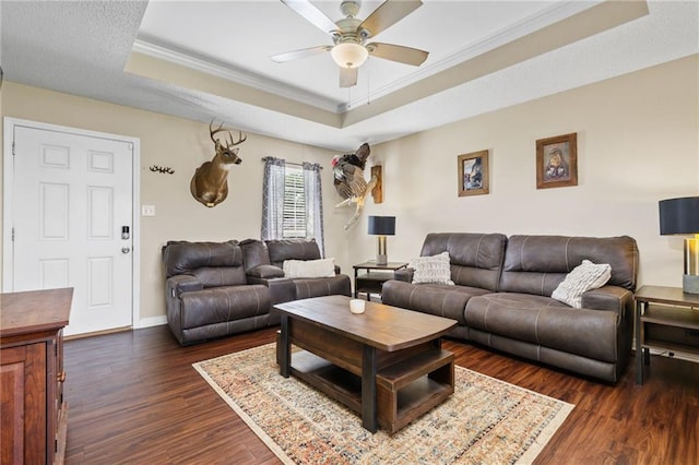 13578 James Copeland Dr, Mobile, AL 36695 - living room featuring a raised ceiling, crown molding, a ceiling fan, dark wood-style floors, and baseboards
