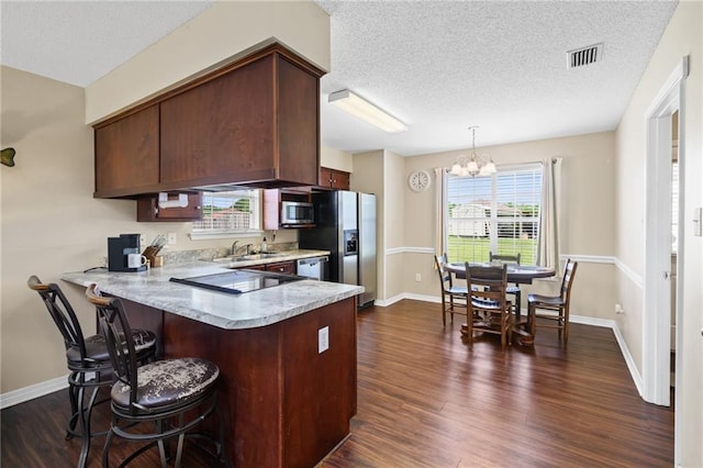 13578 James Copeland Dr, Mobile, AL 36695 - kitchen with appliances with stainless steel finishes, light countertops, a chandelier, a peninsula, and dark wood-style floors