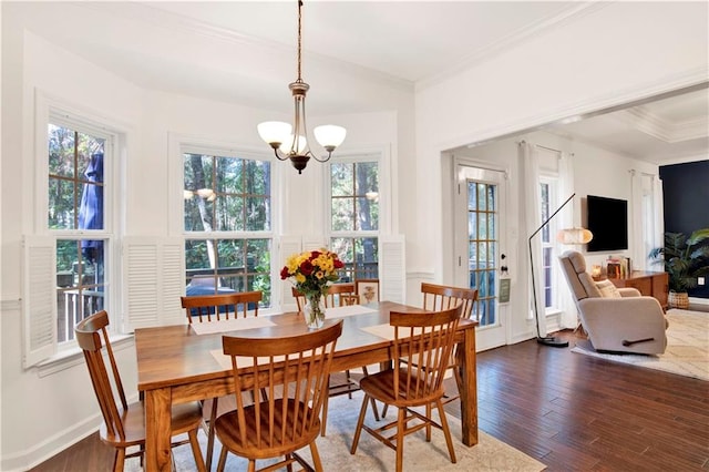 dining room featuring ornamental molding, dark wood-type flooring, and a notable chandelier