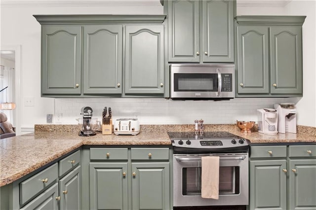 kitchen with decorative backsplash, green cabinets, crown molding, and stainless steel appliances