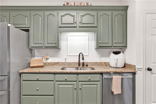 kitchen featuring green cabinets, decorative backsplash, sink, and stainless steel appliances