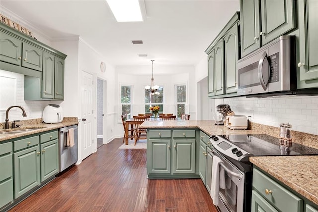 kitchen featuring sink, hanging light fixtures, stainless steel appliances, green cabinets, and dark hardwood / wood-style flooring