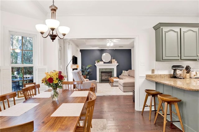 dining room featuring ceiling fan with notable chandelier, hardwood / wood-style flooring, and crown molding