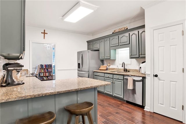 kitchen with backsplash, dark wood-type flooring, sink, ornamental molding, and appliances with stainless steel finishes