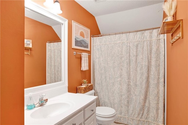 bathroom featuring a textured ceiling, vanity, lofted ceiling, and toilet