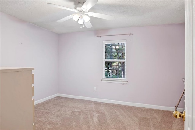 carpeted spare room with ceiling fan and a textured ceiling