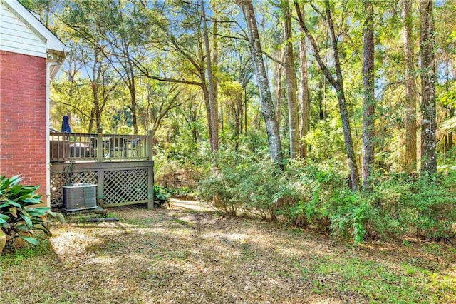 view of yard with a deck and central AC