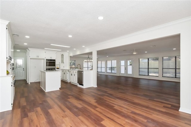 kitchen with white cabinets, dark hardwood / wood-style flooring, stainless steel appliances, and a textured ceiling