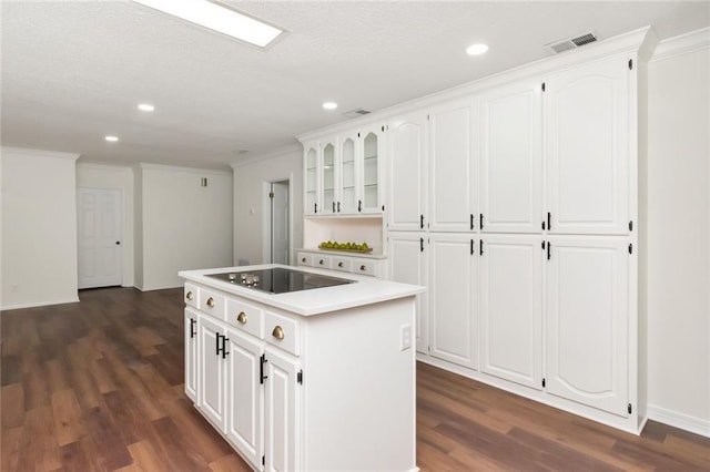 kitchen with white cabinets, a kitchen island, and black electric stovetop