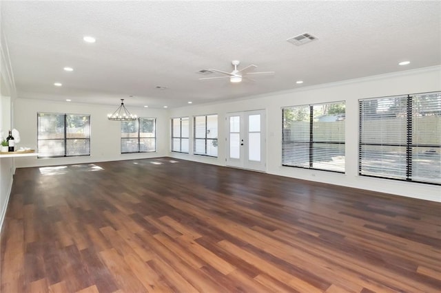 unfurnished living room with hardwood / wood-style floors, ceiling fan with notable chandelier, plenty of natural light, and crown molding