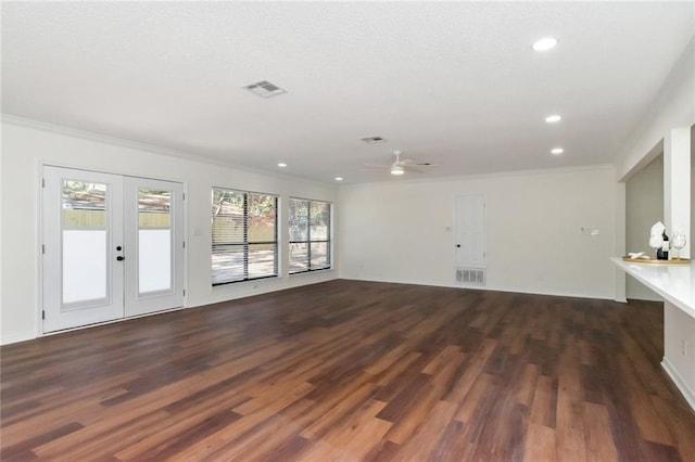 unfurnished living room with french doors, crown molding, ceiling fan, and dark wood-type flooring