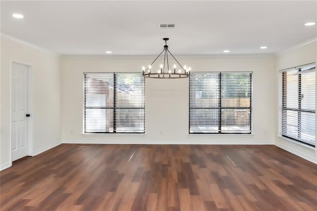 unfurnished dining area with dark hardwood / wood-style floors, ornamental molding, and an inviting chandelier