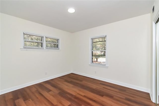 unfurnished room with hardwood / wood-style flooring and a healthy amount of sunlight