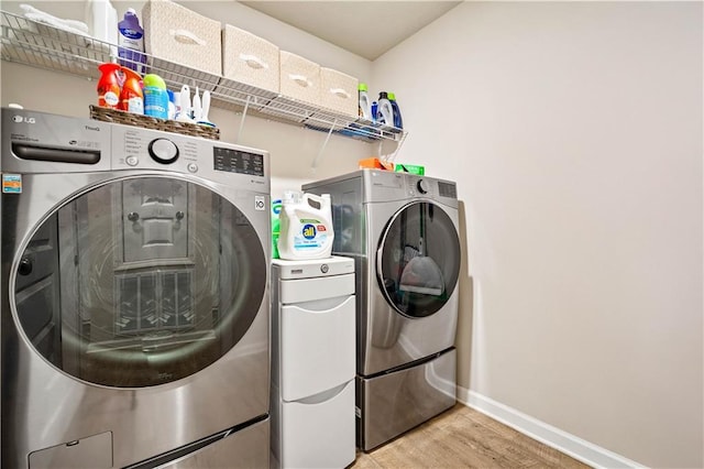 laundry room with separate washer and dryer and hardwood / wood-style flooring