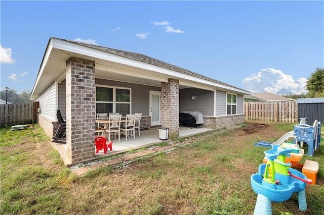 rear view of house featuring a yard and a patio