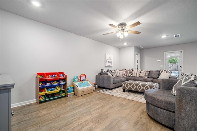 living room with ceiling fan and hardwood / wood-style flooring