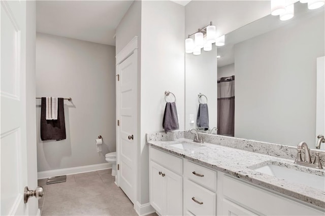 bathroom with tile patterned flooring, vanity, and toilet