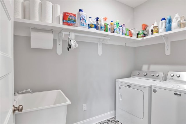 laundry area with separate washer and dryer and sink