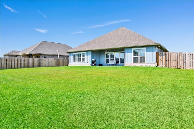 rear view of property with a lawn