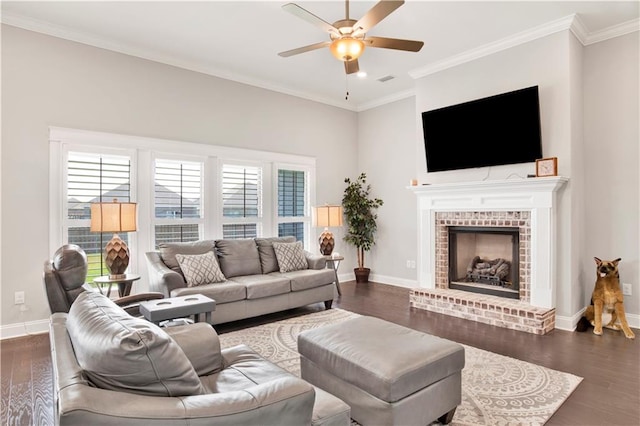 living room with ornamental molding, ceiling fan, a fireplace, and dark wood-type flooring