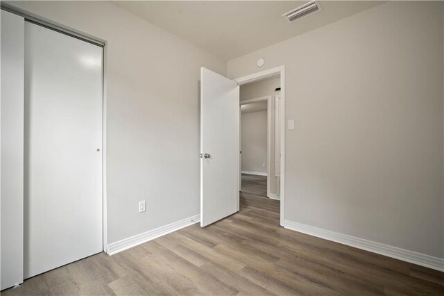1452 Morlee Dr E, Mobile, AL 36618 - unfurnished bedroom featuring wood finished floors, baseboards, and a closet