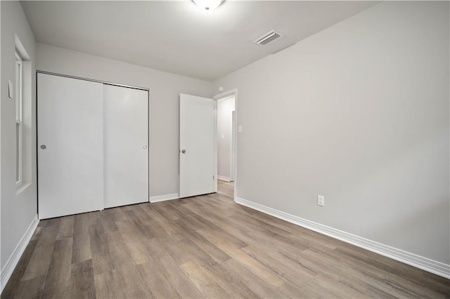1452 Morlee Dr E, Mobile, AL 36618 - unfurnished bedroom with baseboards, wood finished floors, and a closet